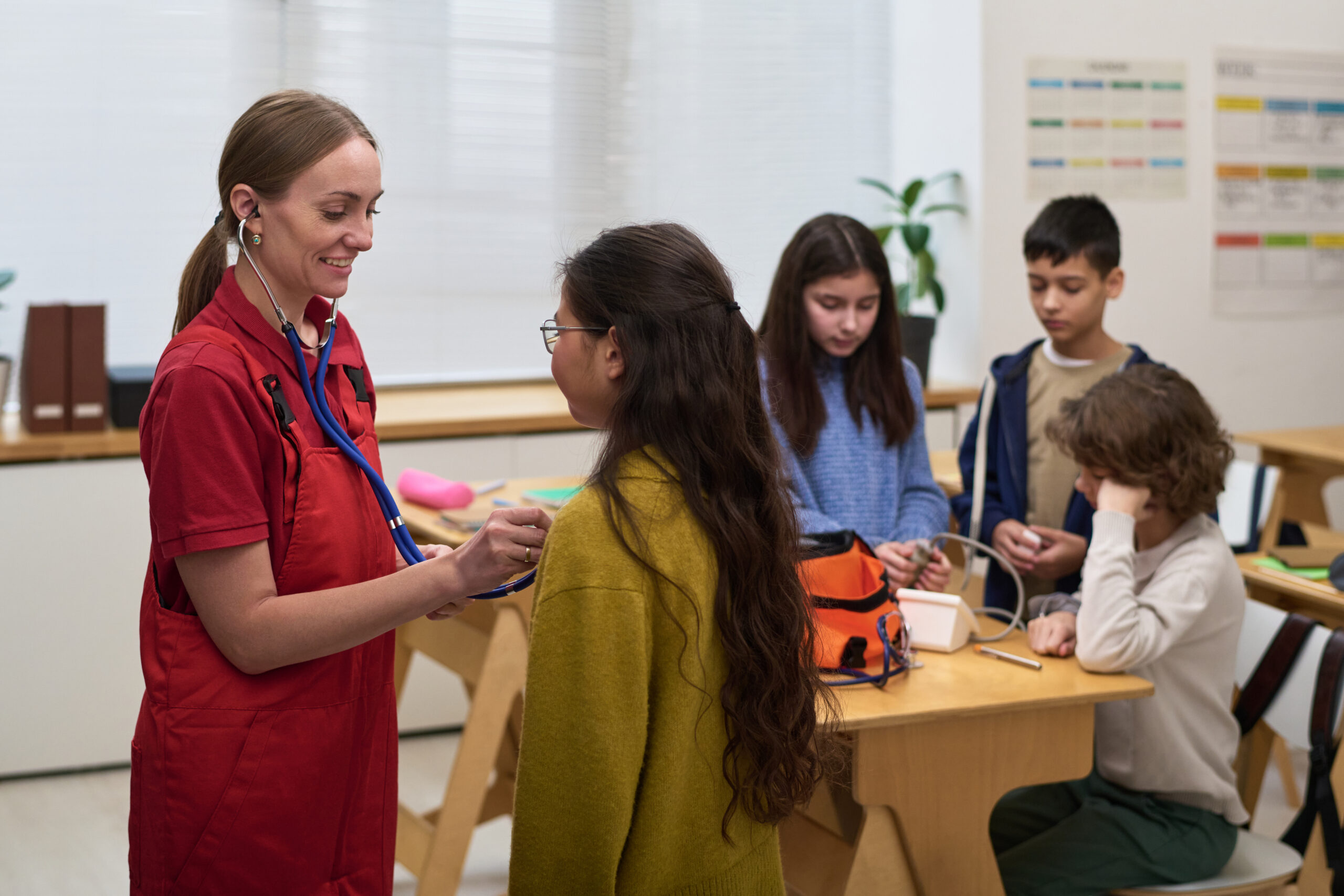 Caucasian Female Nurse Examining Preteen Girl during School Health Checkup